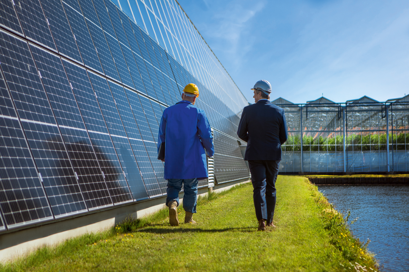 2 Männer laufen vor einer Solarpanele 